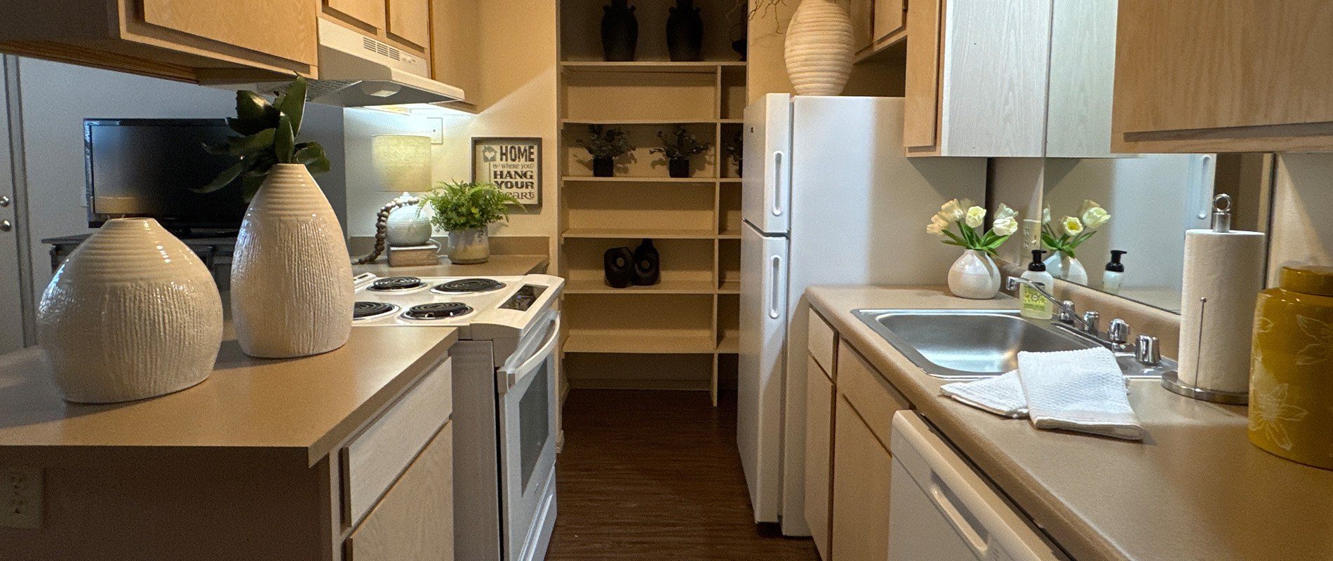 A kitchen with white appliances and wooden cabinets.